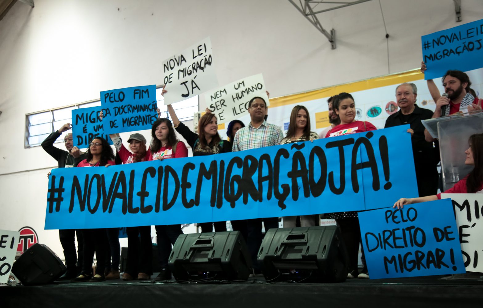 Participantes do VII Fórum Social Mundial das Migrações erguem cartazes da campanha por uma nova lei de migração no Brasil. Foto: João Paulo Brito/Conectas