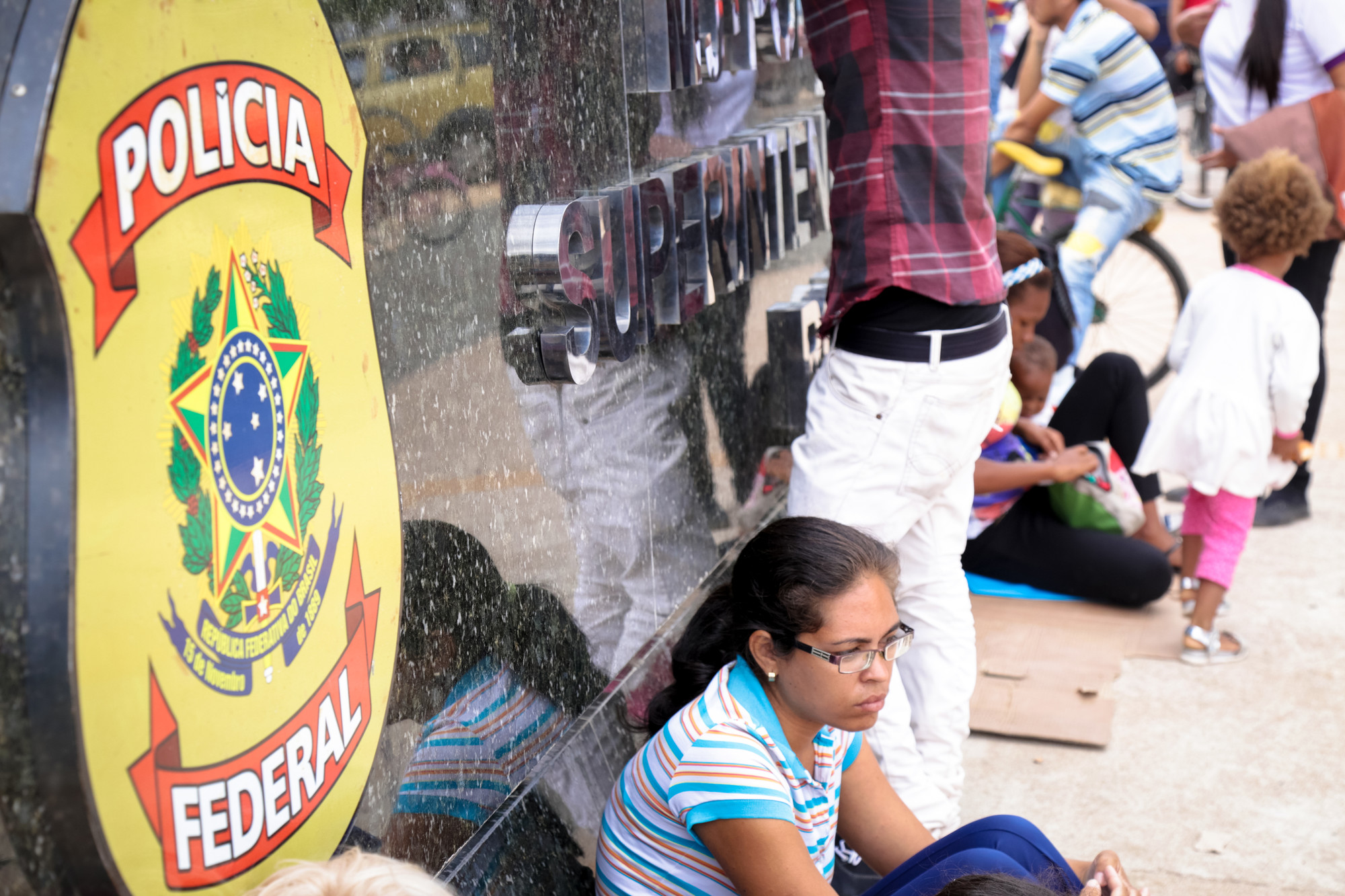 Fila de venezuelanos diante da Superintendência da Polícia Federal de Boa Vista em tentativa de regularizar a situação migratória no Brasil.(Leonardo Medeiros/Conectas - fev.2018)