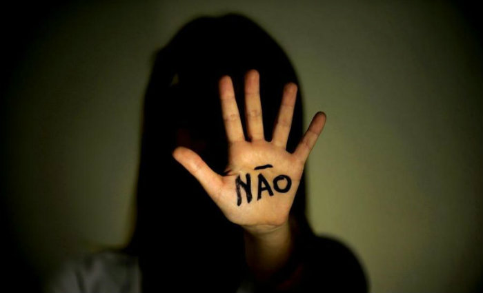 Silhouette of a girl with extended hand on which is written the word “no”.
