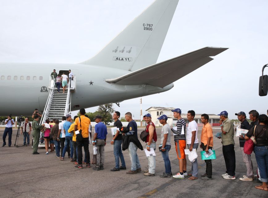 Venezuelan immigrants lining up to board a plane