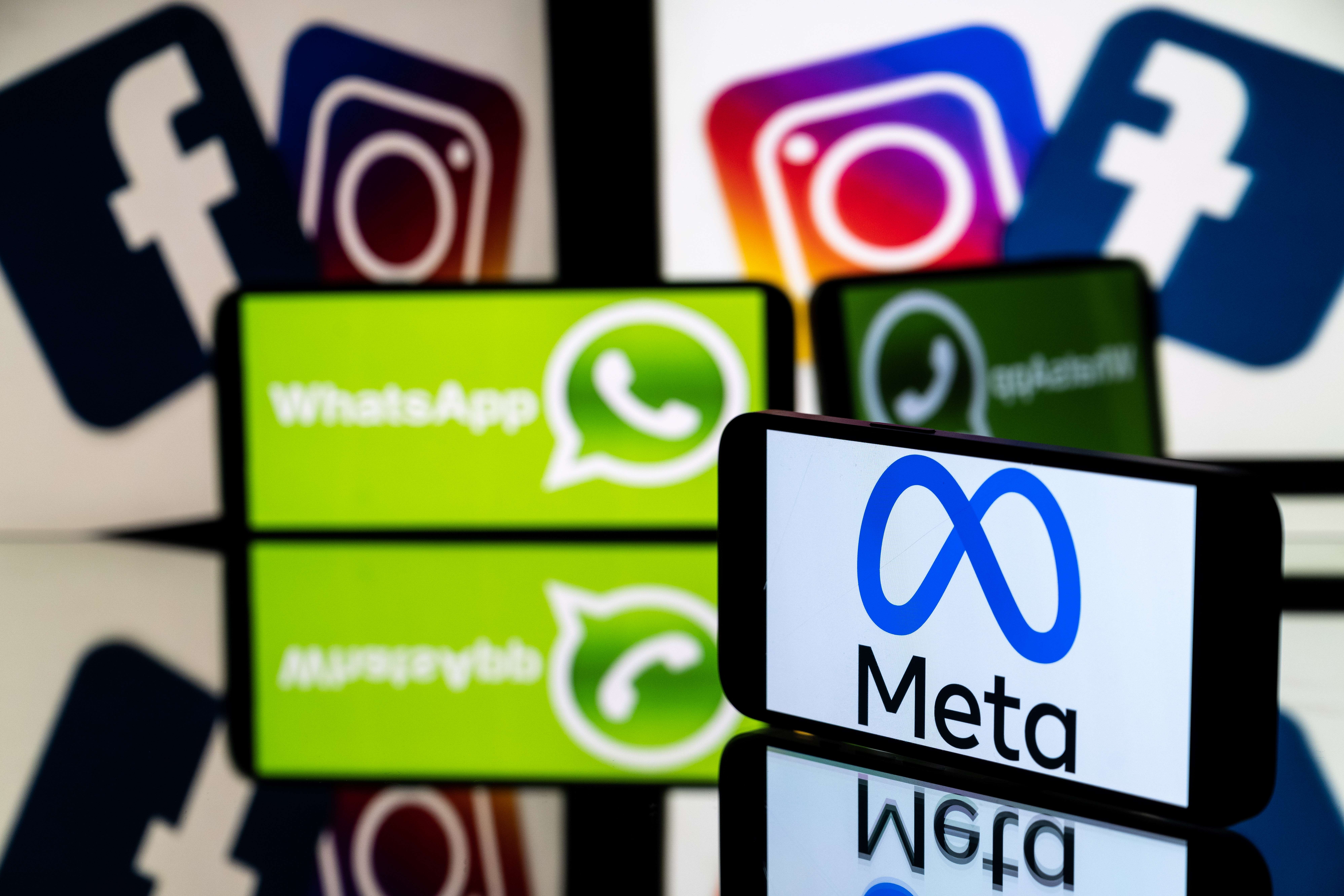 This picture taken on January 12, 2023 in Toulouse, southwestern France shows a smartphone and a computer screen displaying the logos of the Instagram, Facebook, WhatsApp and their parent company Meta. (Photo by Lionel BONAVENTURE / AFP)